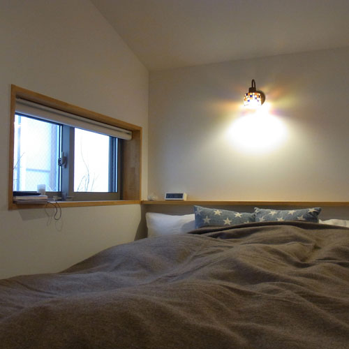 中庭を介してリビングの南側にある平屋の寝室。
「離れ」のような感覚で、窓からは庭の木々
そして、その向こうにリビングが見える。