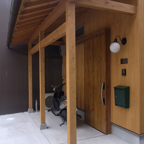 軒を深くした玄関
板張の壁、化粧垂木や梁・柱が
落ち着いた雰囲気を作っている。