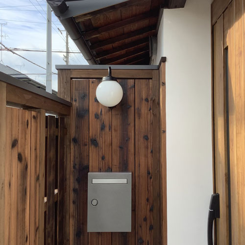 玄関外部
前面道路が近いので、アイストップを兼ねた木塀
外壁と塀は同材の焼杉を使用して意匠を合わせている。